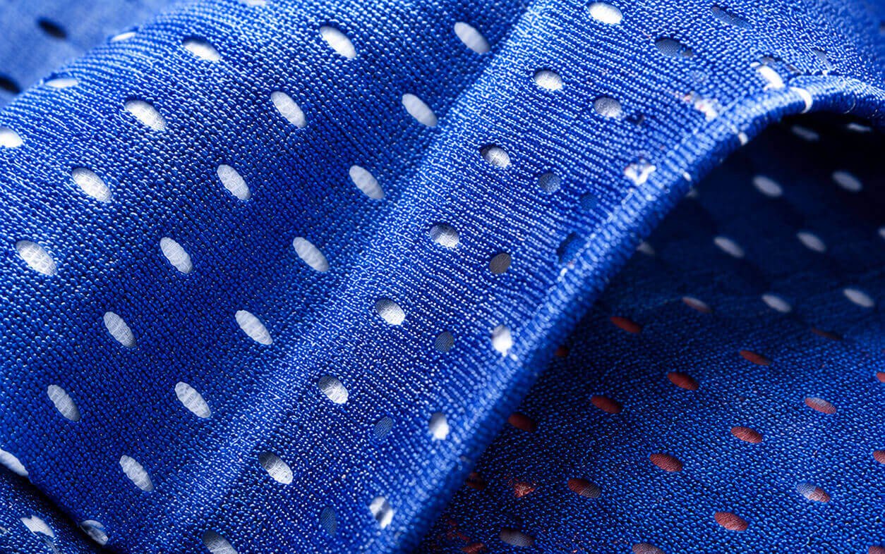 "A macro close-up of a fold in the royal blue mesh banner material. This detailed texture view emphasizes the high-density array of precision-perforated air holes, showcasing the light-weight and pliable yet durable nature of the mesh fabric.