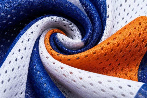 VIBRANT, UV-RESISTANTHIGH-RESOLUTION PRINTING An extreme macro close-up of a swirl of royal blue and white mesh fabric. This intricate view highlights the high-resolution direct-to-mesh printing quality, showcasing sharp color transitions and deep saturation on the perforated fabric without blurring, confirming vibrant color reproduction.